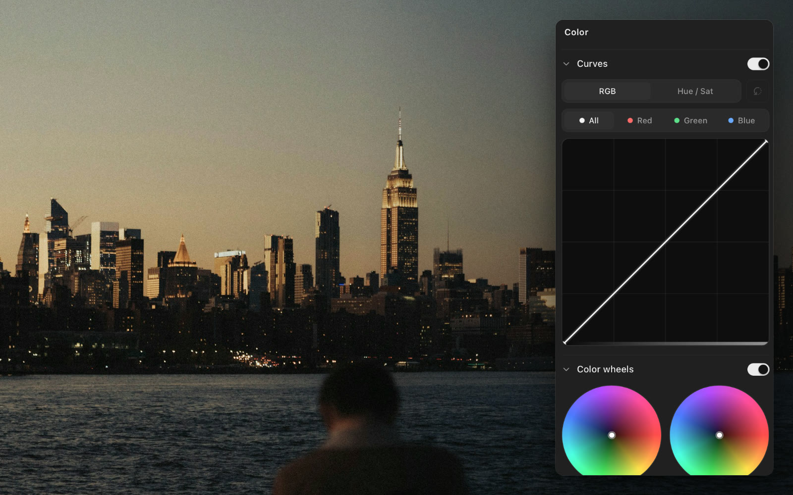 A city skyline at dusk, with the color inspector open beside it: RGB curves and color wheels.